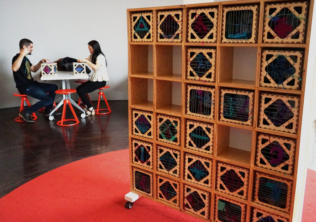 two visitors working on mindful weaving
