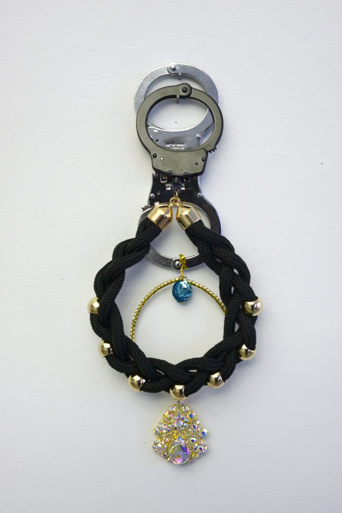 Kambui Olujimi, "Stowaway," from the series "Killing Time," 2017. Handcuffs and costume jewelry, 15 x 6 inches. Courtesy of the artist. © Kambui Olujimi.