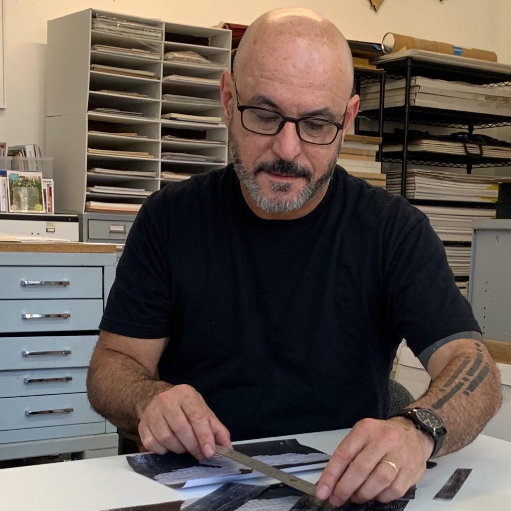 Photo of printmaker working in his studio.